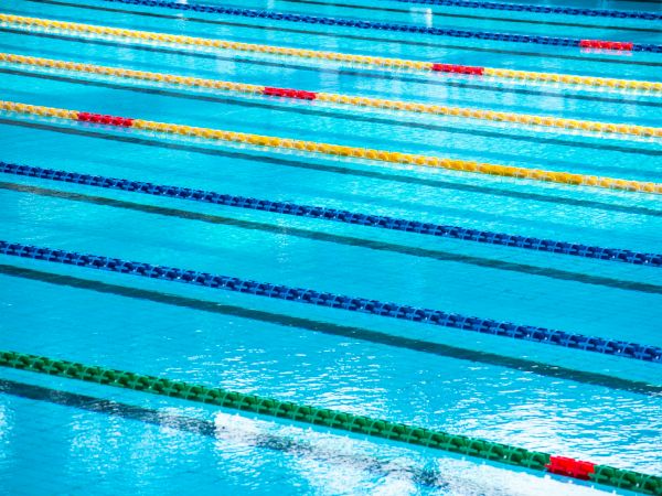 Colorful swimming pool lanes with blue water and lane dividers in red, yellow, green, and blue.