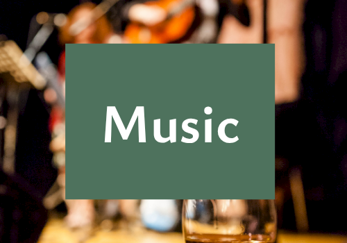 A blurred live music scene with instruments in the background, a champagne flute in front, and the word &ldquo;Music&rdquo; displayed.